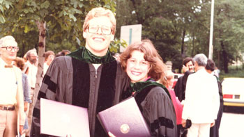 A man and a woman in graduation gowns